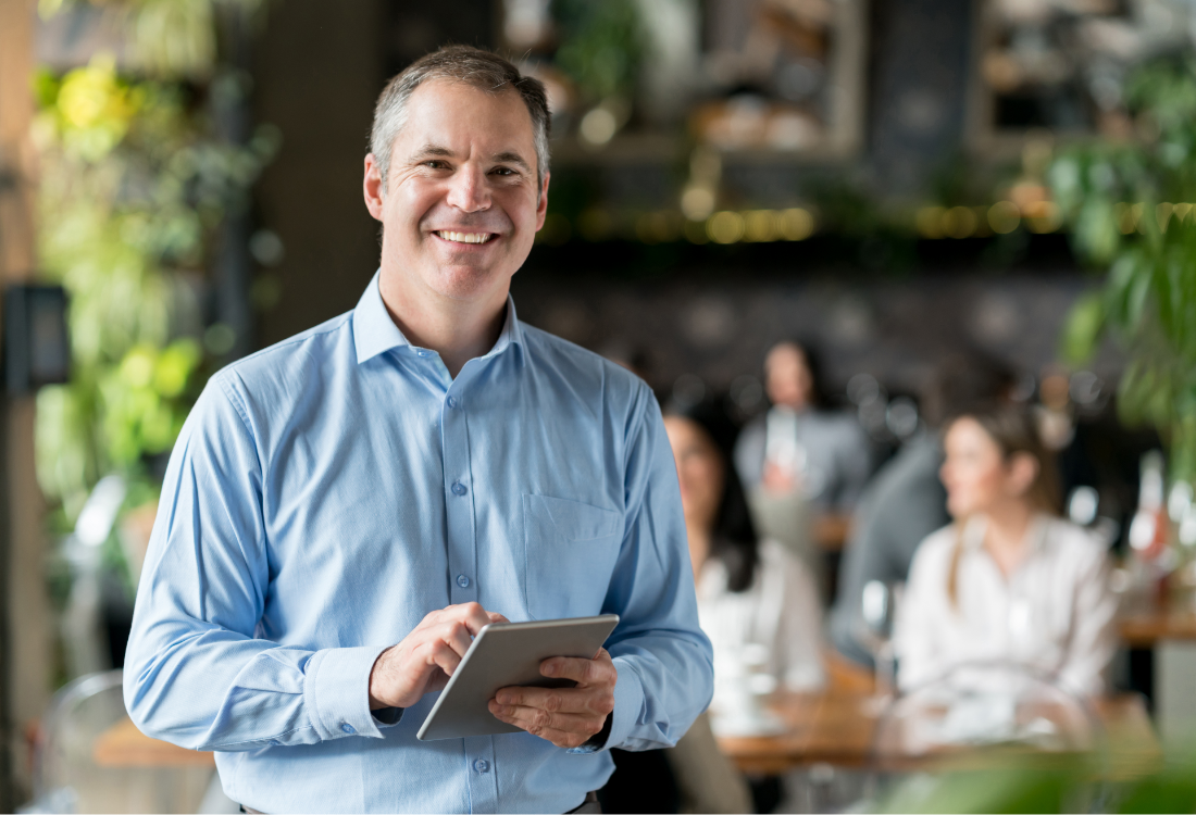 Smiling business owner using a tablet to manage accounts with cloud accounting software.