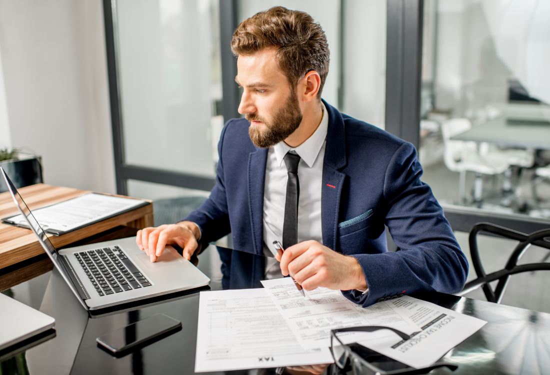 A male accountant on his laptop ensuring he is staying on top of changing UK tax and financial regulations.  