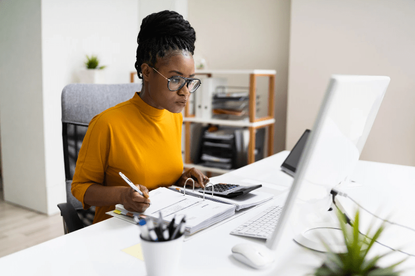 A woman in an office researching into the difference between an accountant and a chartered accountant 