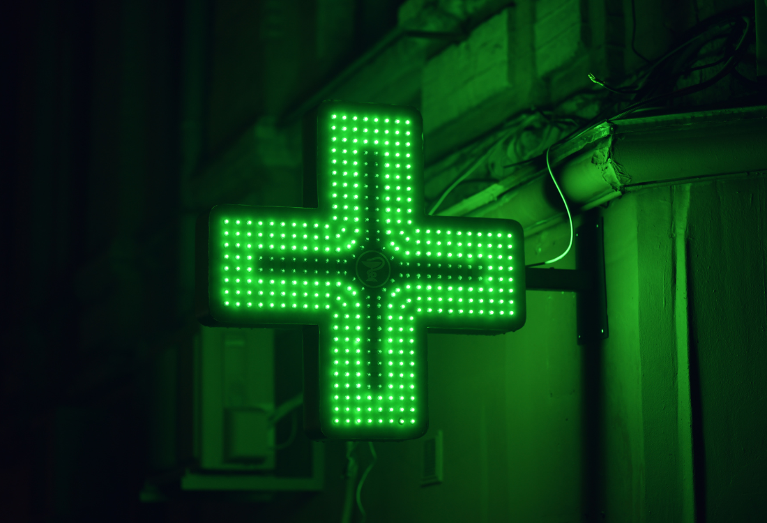A pharmacy sign glowing at night. 