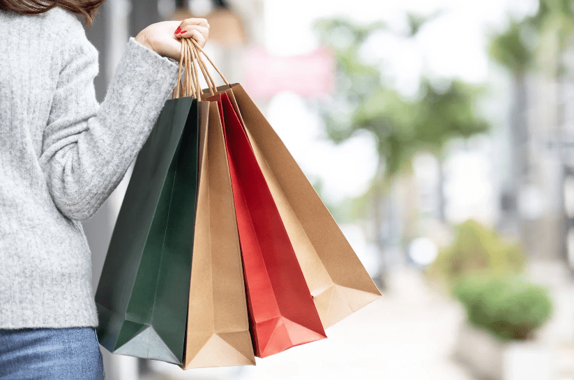 A woman carrying shopping bags after visiting the Wilkos administration sale due to Wilkos going into administration because of their poor management accounting.