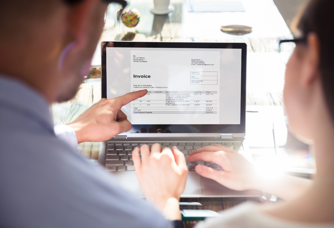 Two business partners analyse their tax invoice for this year.  