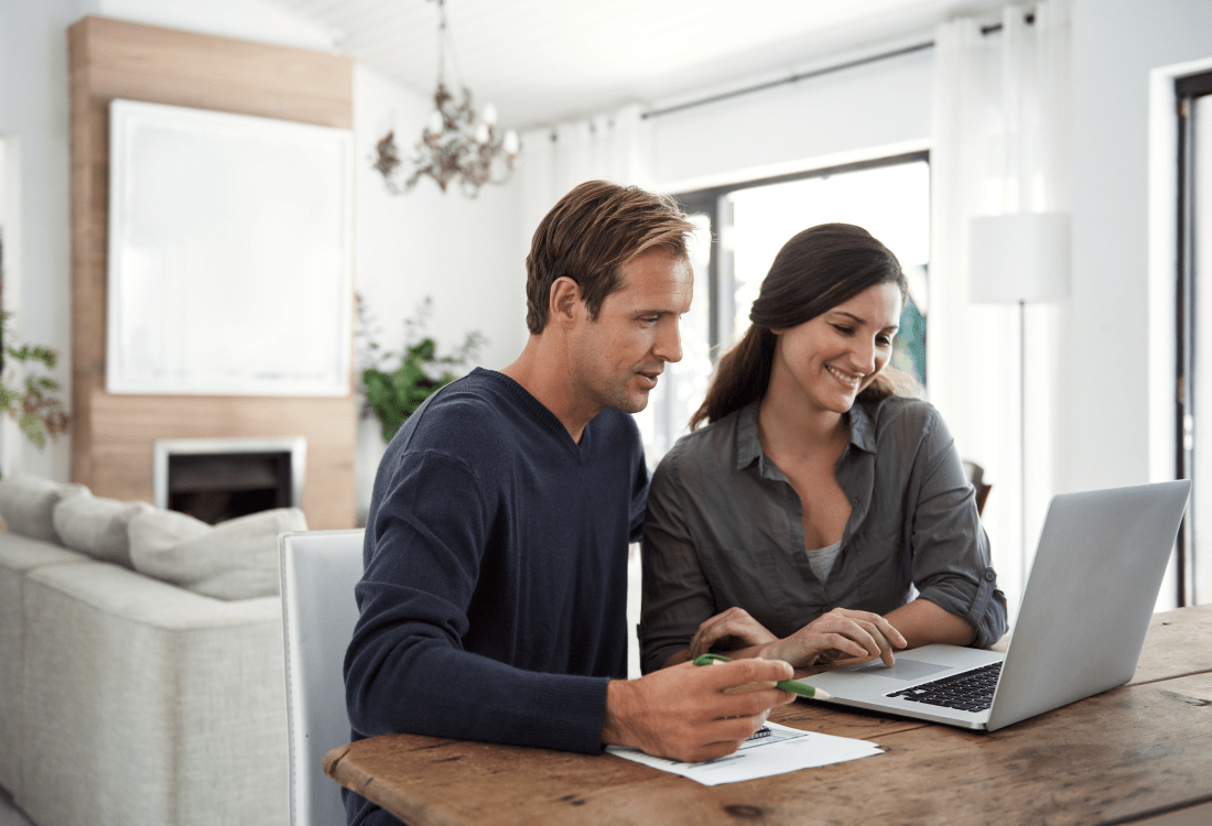 A man and a woman sitting at the table in a living room using Xero Online Accounting for their small business.